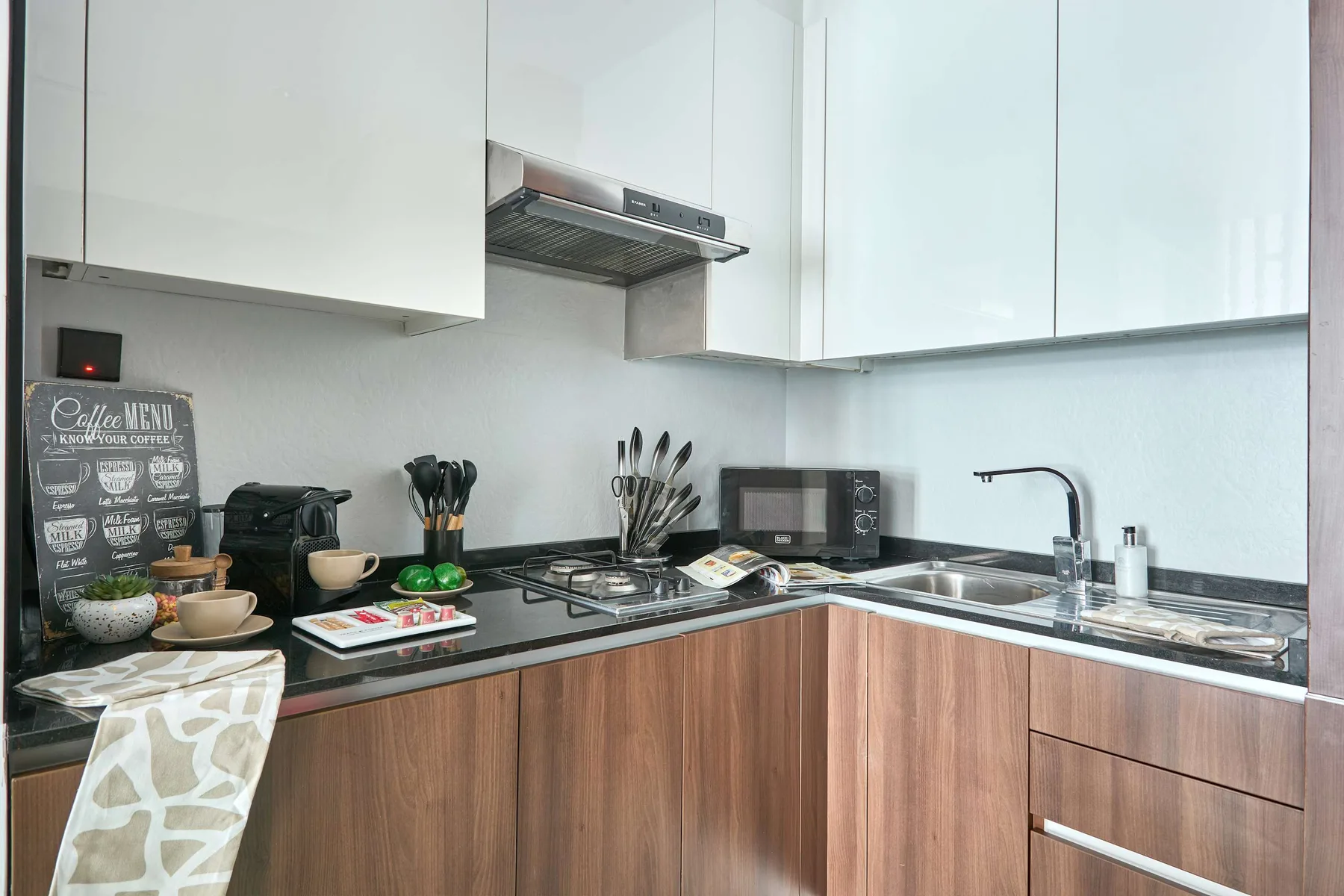 Una cocina moderna con armarios de madera, una placa de cocina y un fregadero.