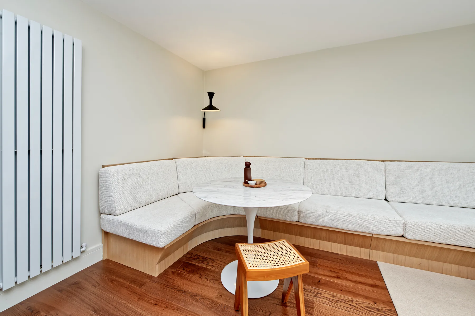 A bright room with curved built-in seating and a small round table.