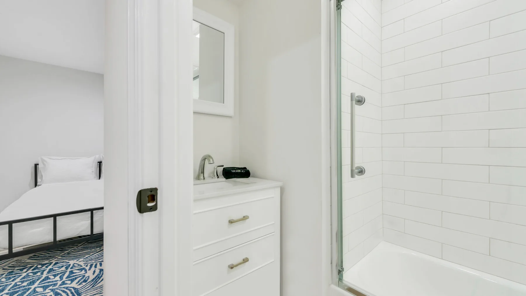 Un baño con lavabo y mueble junto a una ducha alicatada con bañera.