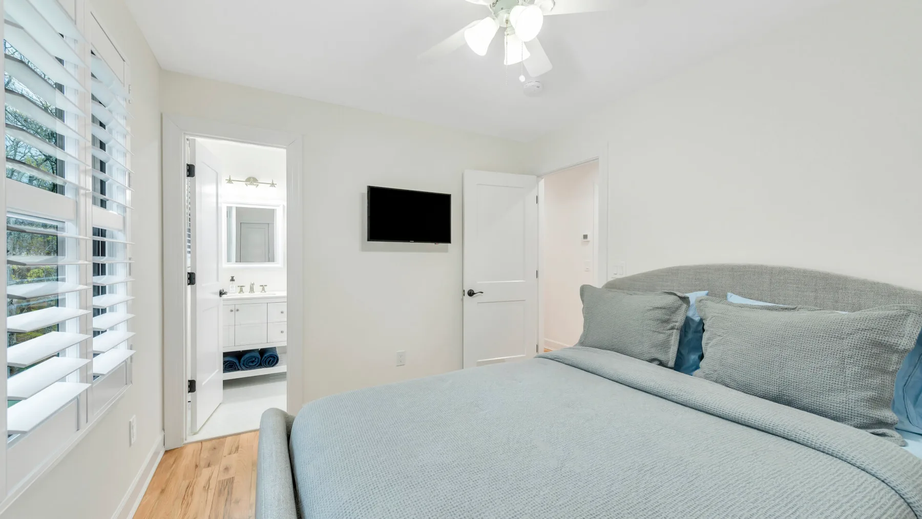 Un dormitorio con una cama grande y un televisor montado en la pared.