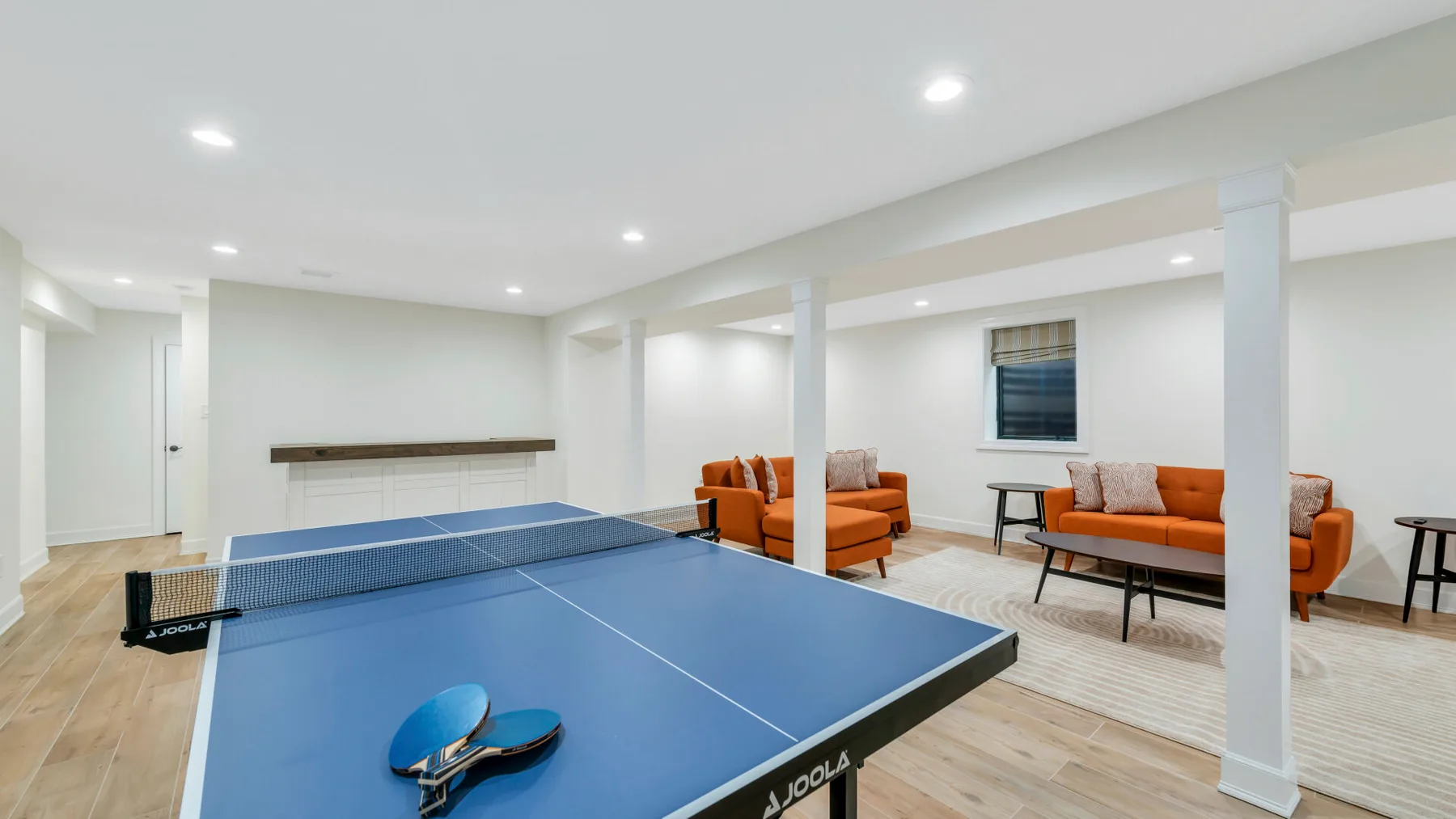 Una sala de recreación combina una mesa de ping-pong azul con asientos naranjas.