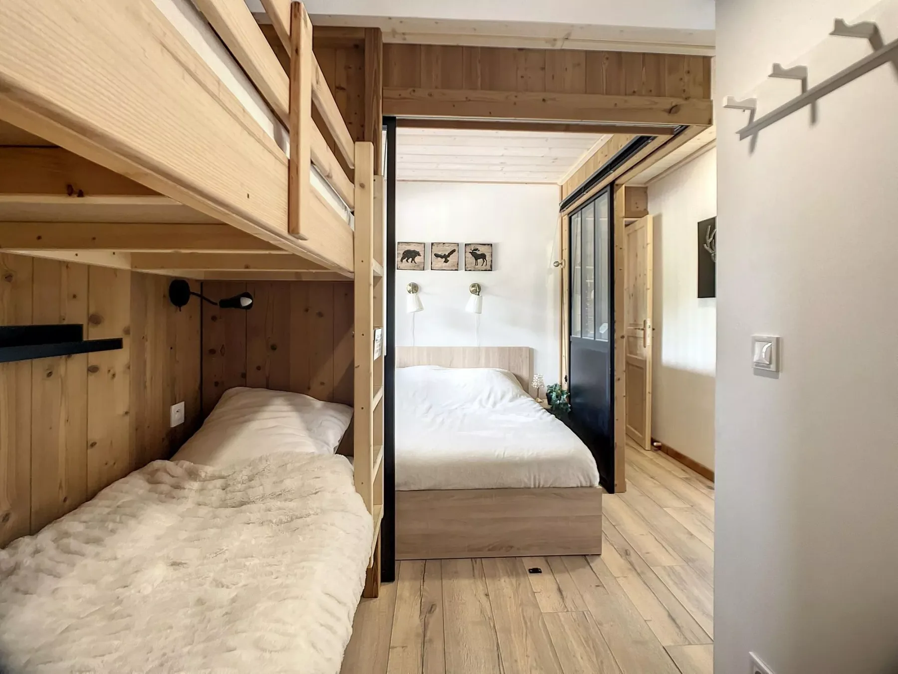 A wood-paneled bedroom with two beds and a wall-mounted light.