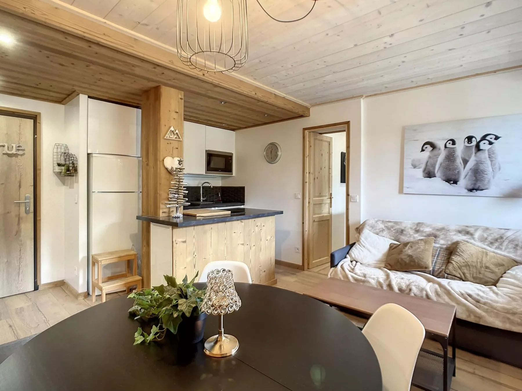 Una sala de estar con mesa de comedor, cocina compacta y sofá.