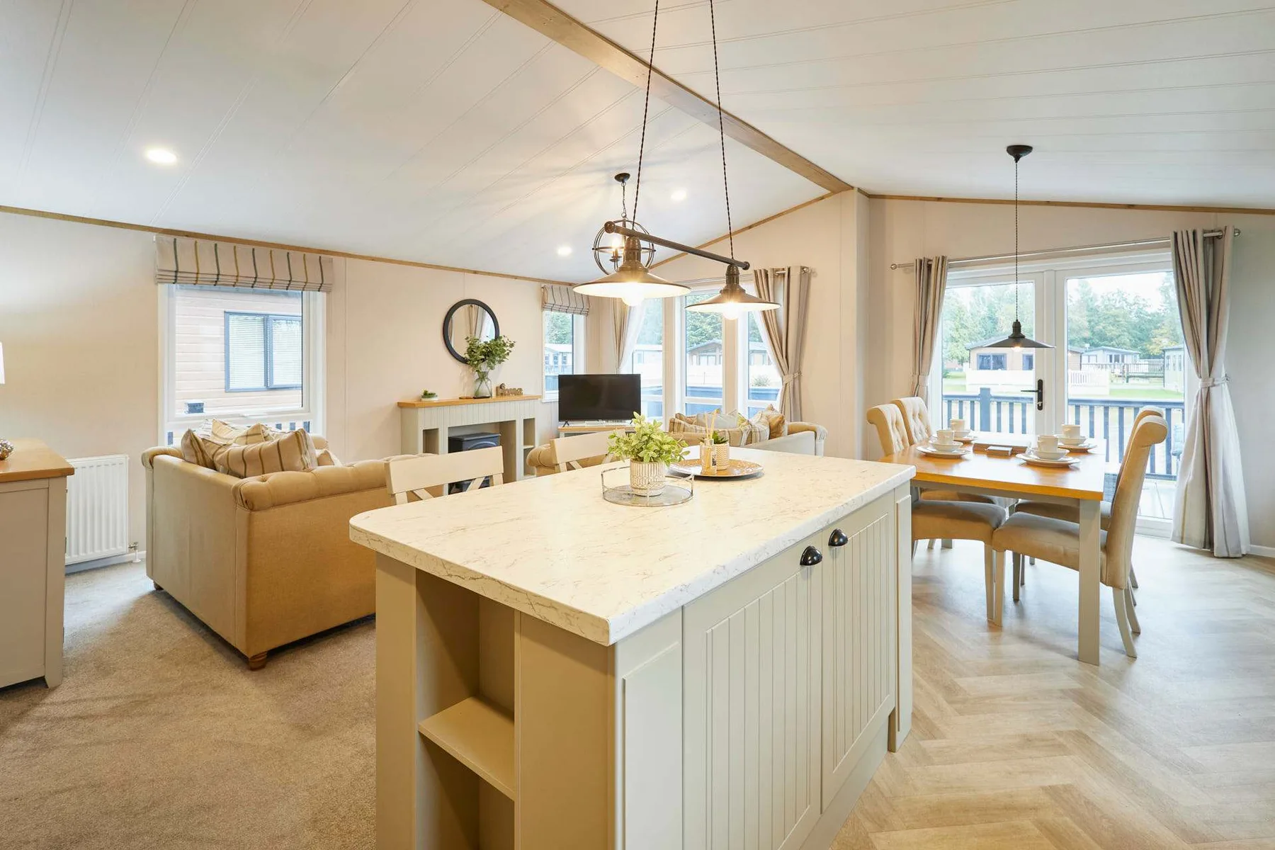 Open-plan kitchen and dining area with a large island and adjoining living space.