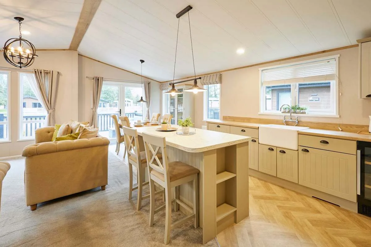Una luminosa cocina-comedor diáfana con una isla central y una zona de estar contigua.