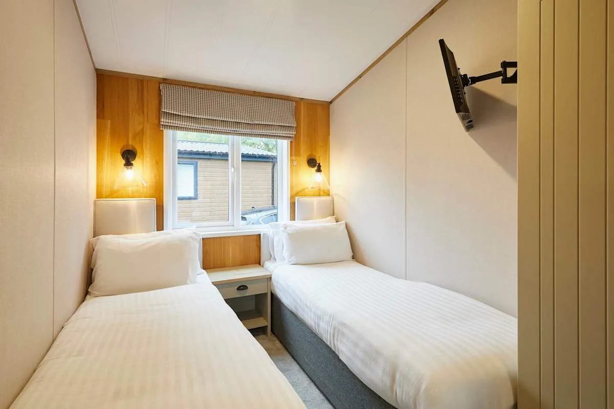 Un dormitorio con dos camas individuales y una ventana entre ellas.