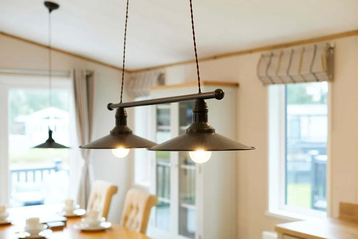 Un comedor con una mesa de madera bajo lámparas colgantes.