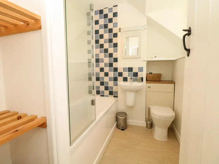 Un baño compacto con bañera, ducha, lavabo e inodoro.