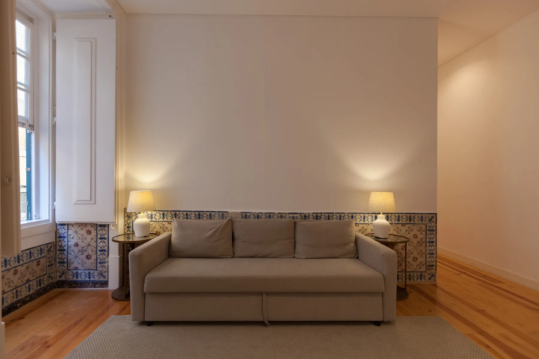 Una sala de estar con asientos bajo una cenefa decorativa de azulejos.
