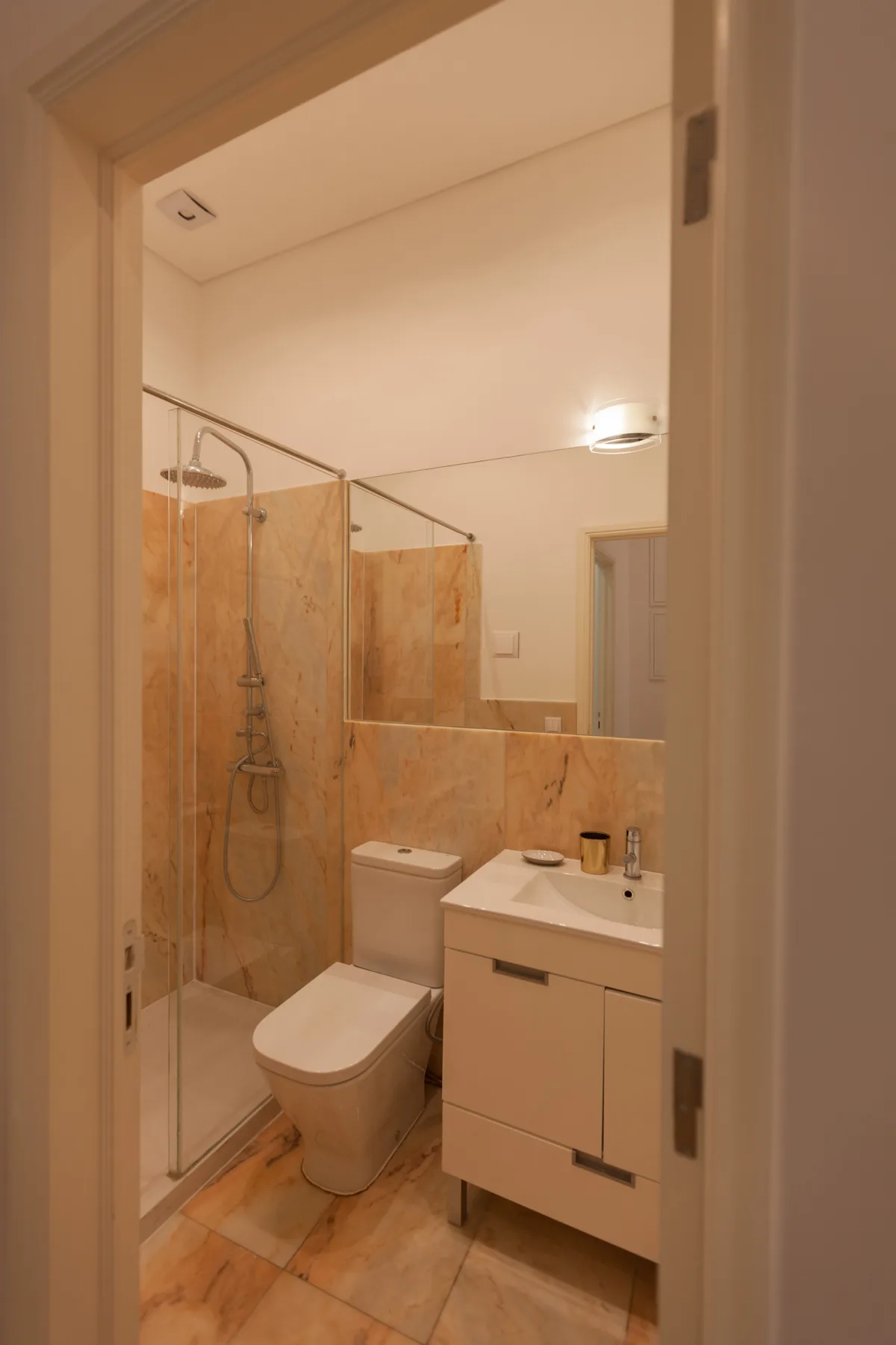 Un baño con ducha de vidrio, inodoro y tocador.