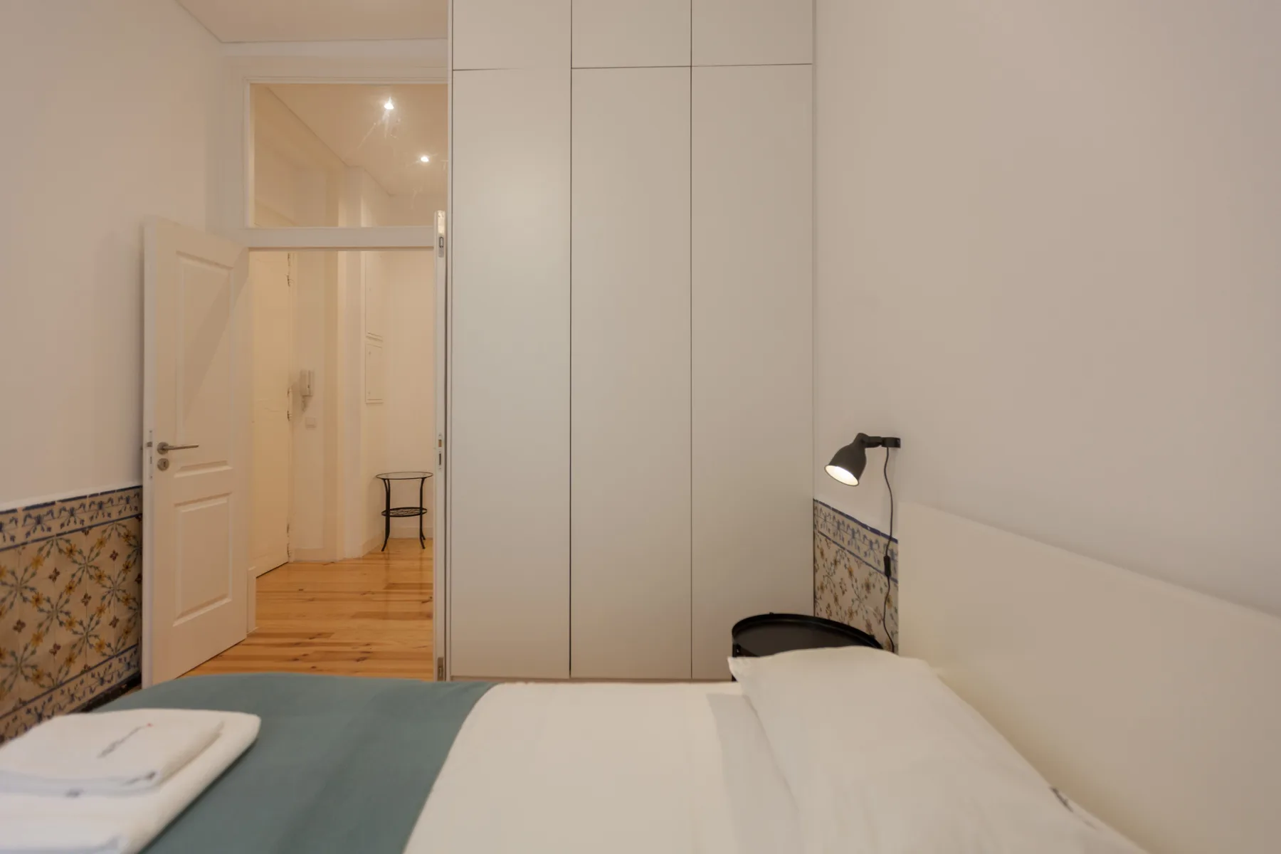 Dormitorio con cama, armarios empotrados y azulejos decorados en las paredes.