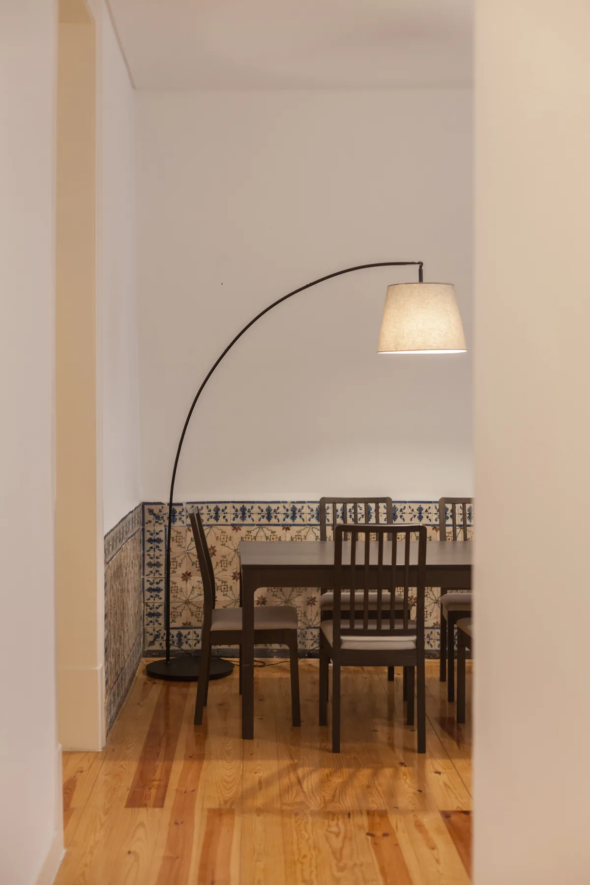 Comedor con asientos de madera, una mesa y azulejos decorados en la pared.