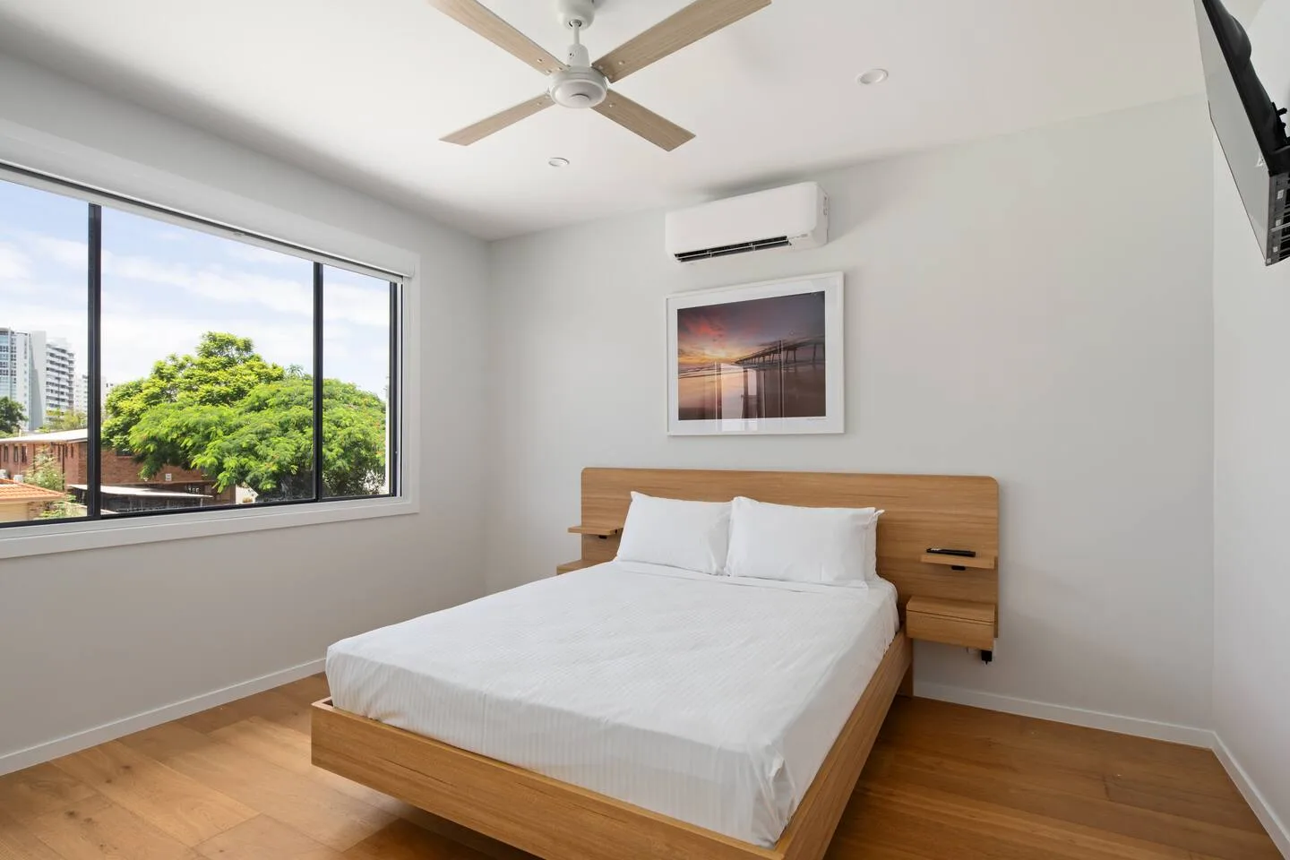 Unwind in the primary bedroom, where a queen bed, calm styling, air conditioning, and a peaceful atmosphere set the tone for restful nights.