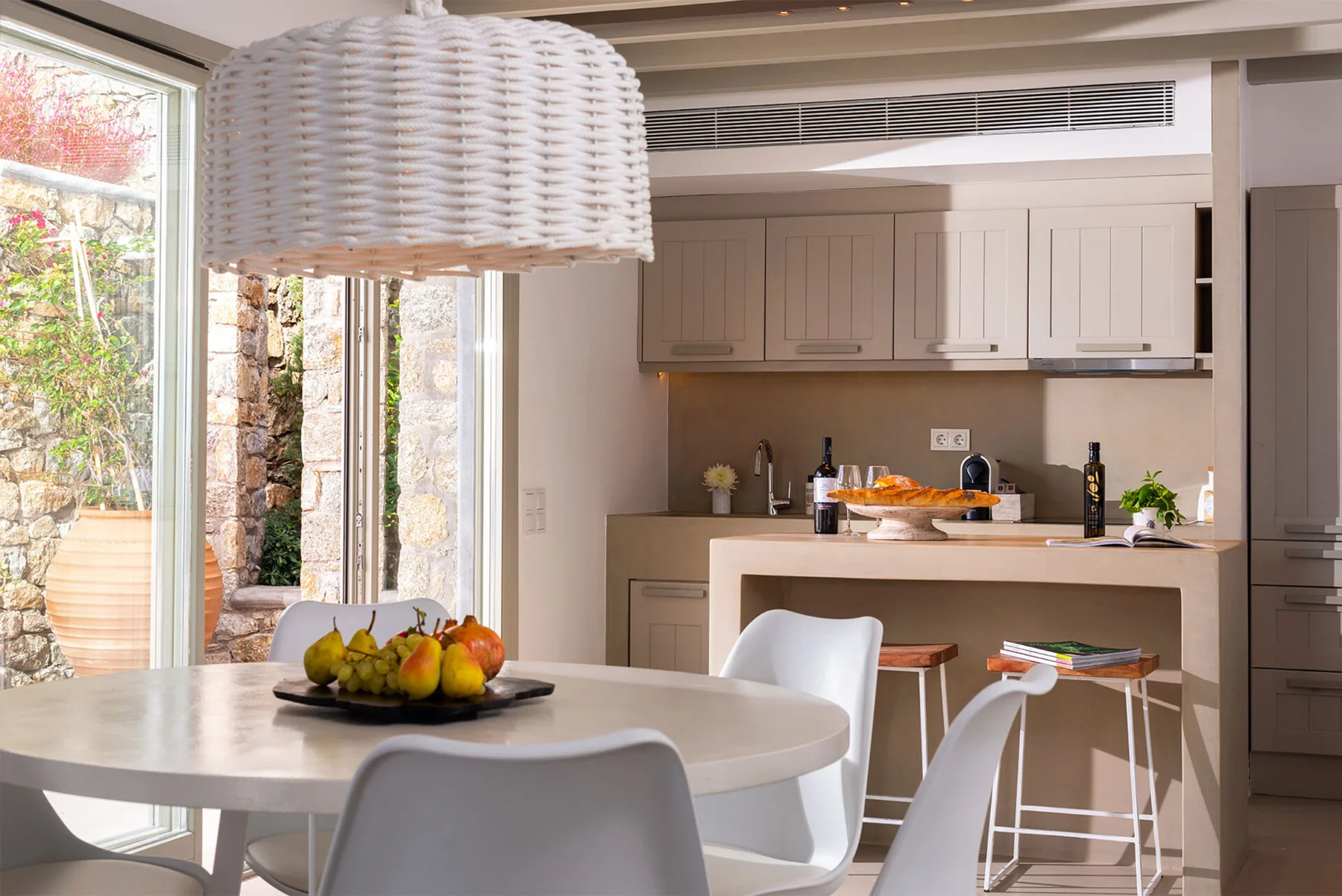 Un comedor luminoso con una mesa redonda junto a una cocina abierta.