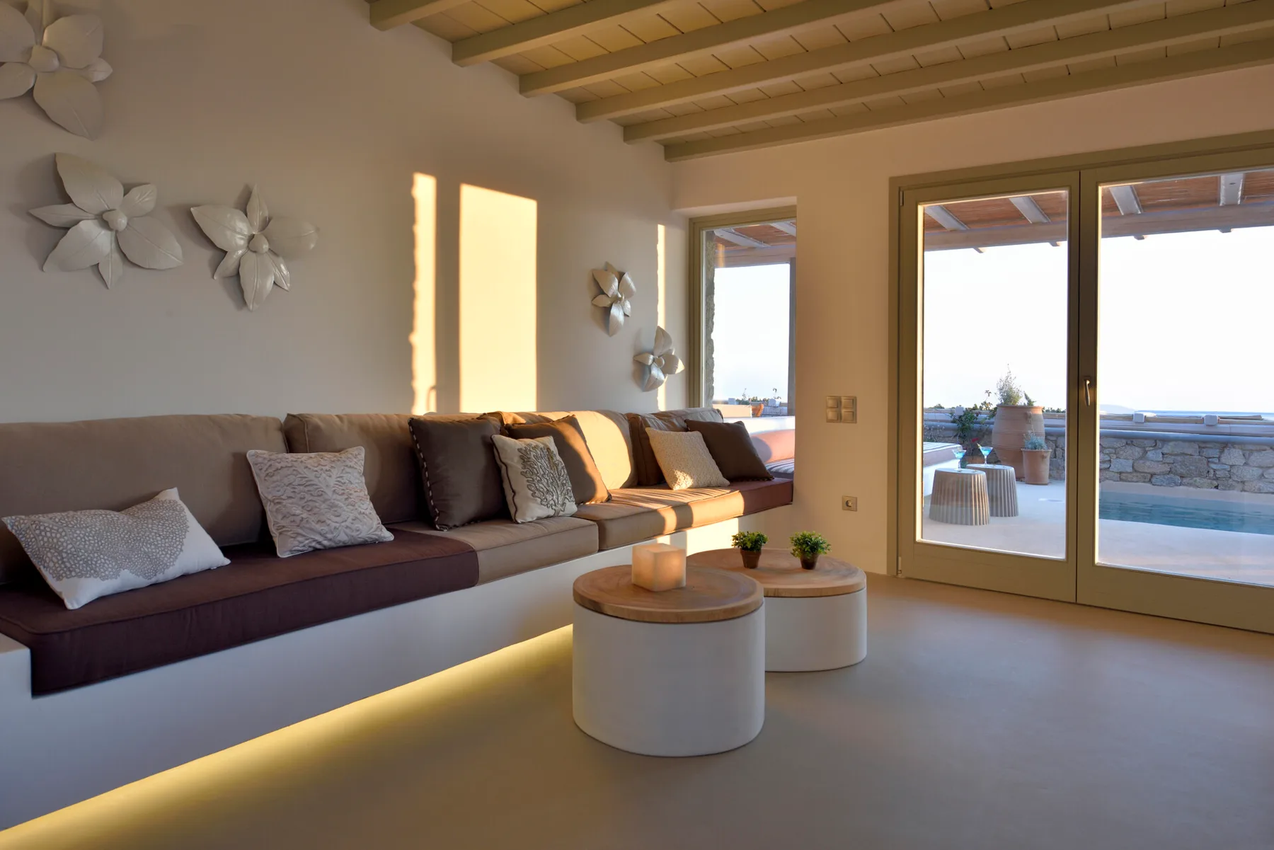 Una luminosa sala de estar con asientos empotrados y puertas de vidrio que dan a un patio.