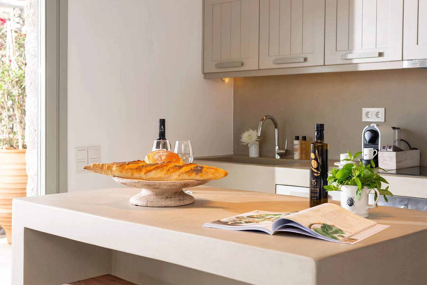 Una cocina luminosa con una isla, pan y un libro abierto.