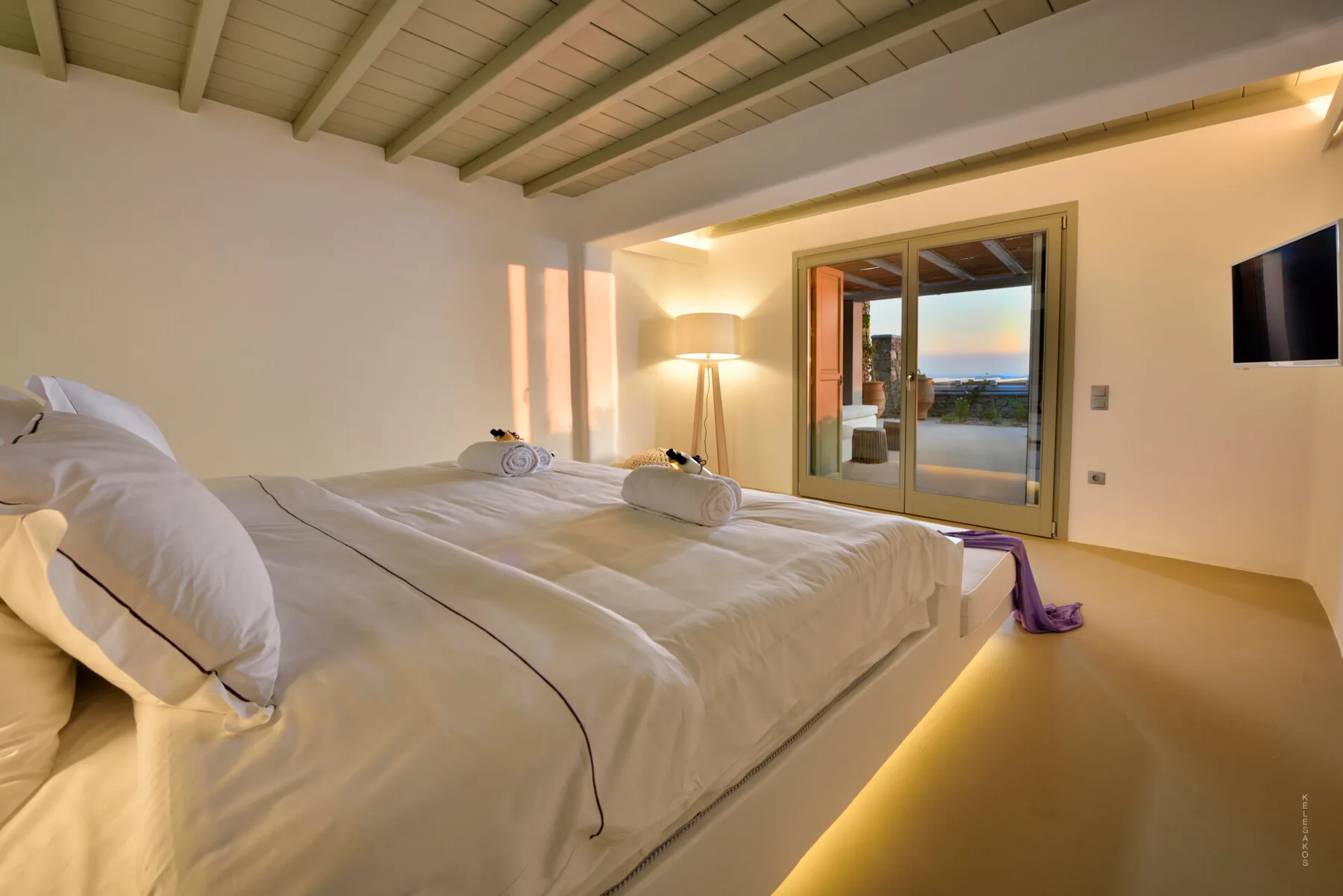 Un dormitorio con una cama grande y puertas de vidrio que dan a un balcón.