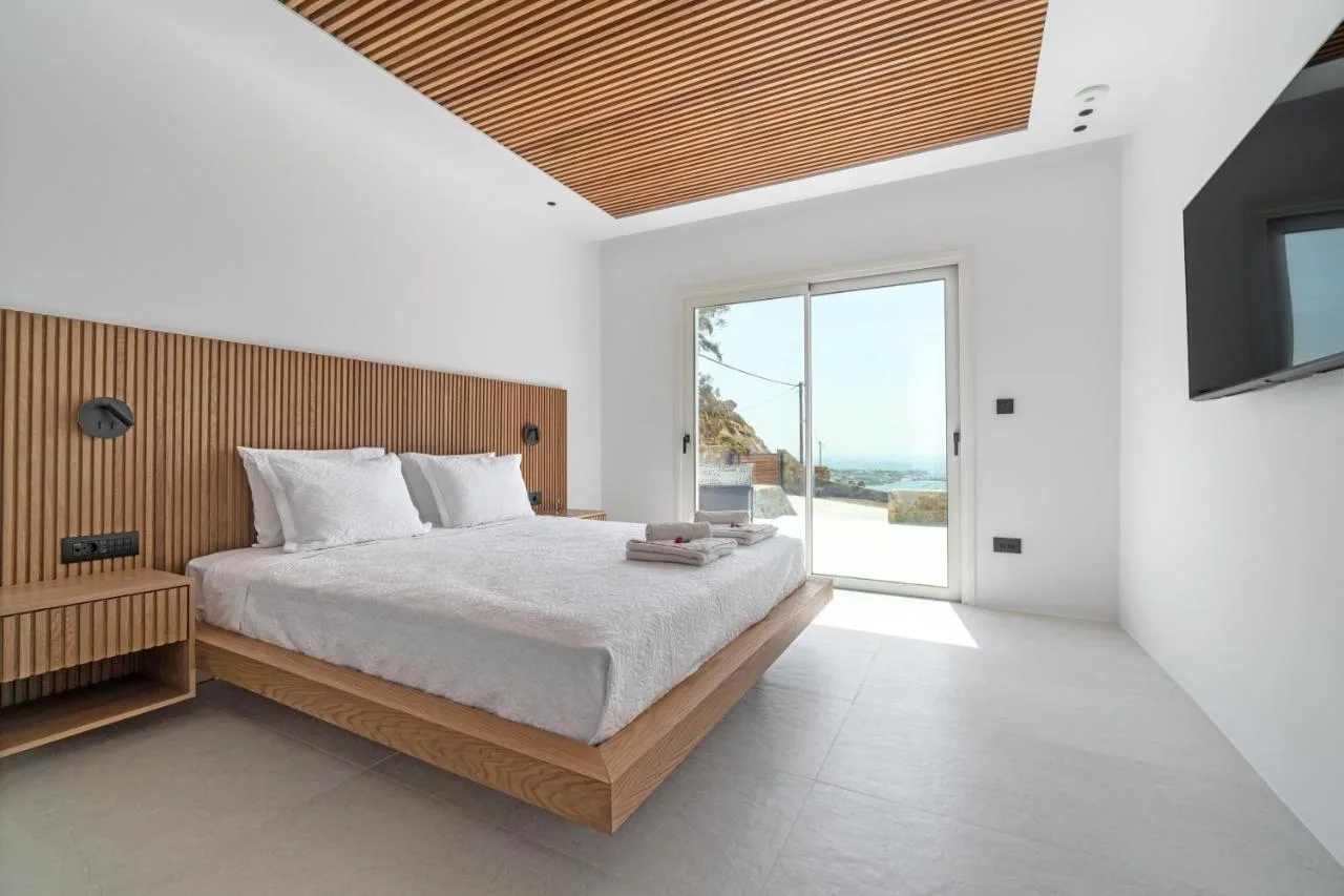 A bright bedroom with a large bed and sliding glass doors.
