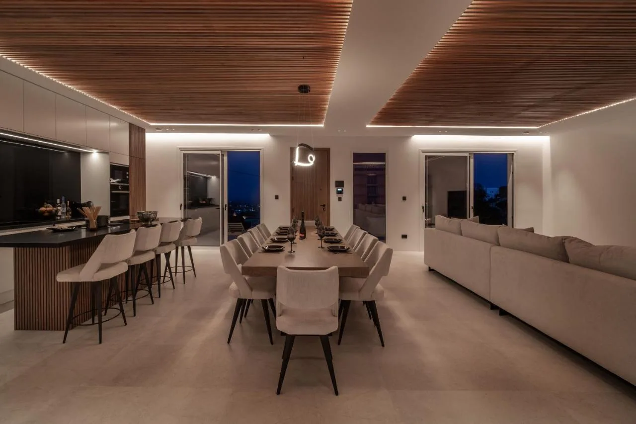 An open-plan dining and living area with a long dining table and seating.
