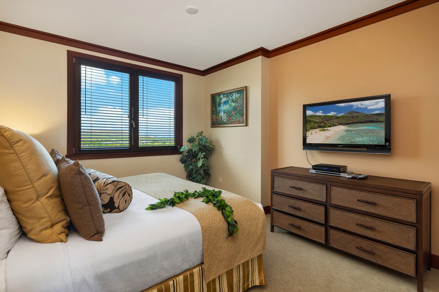 Un dormitorio con una cama, una ventana y un televisor sobre una cómoda.
