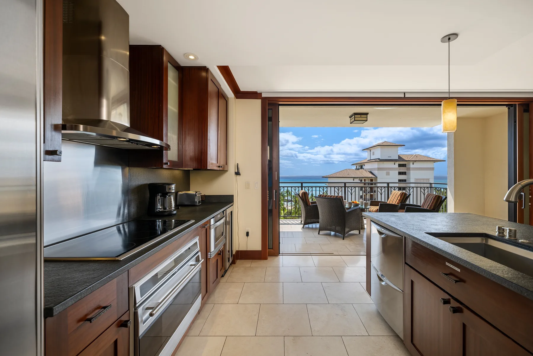 Una cocina moderna se abre a una terraza amueblada con vistas al océano.