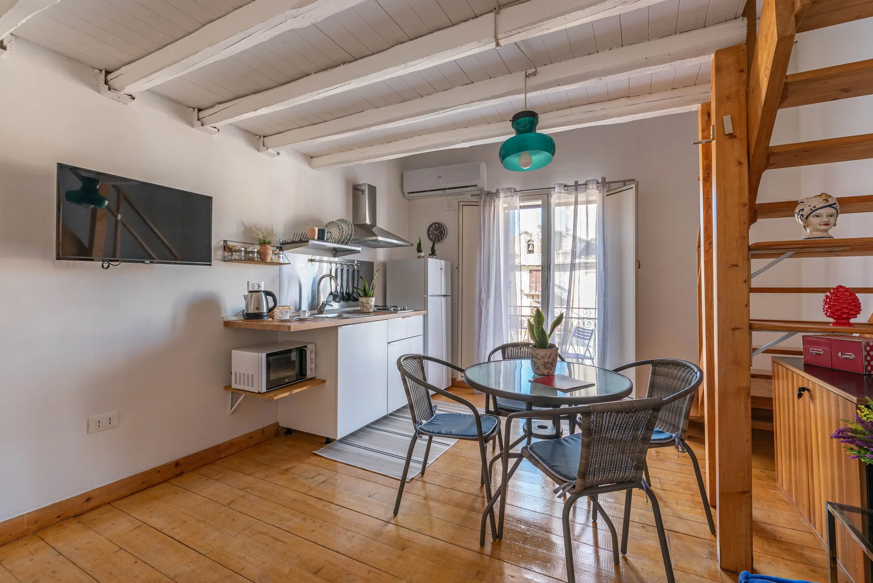 Una cocina-comedor diáfana con una mesa redonda junto a la cocina.