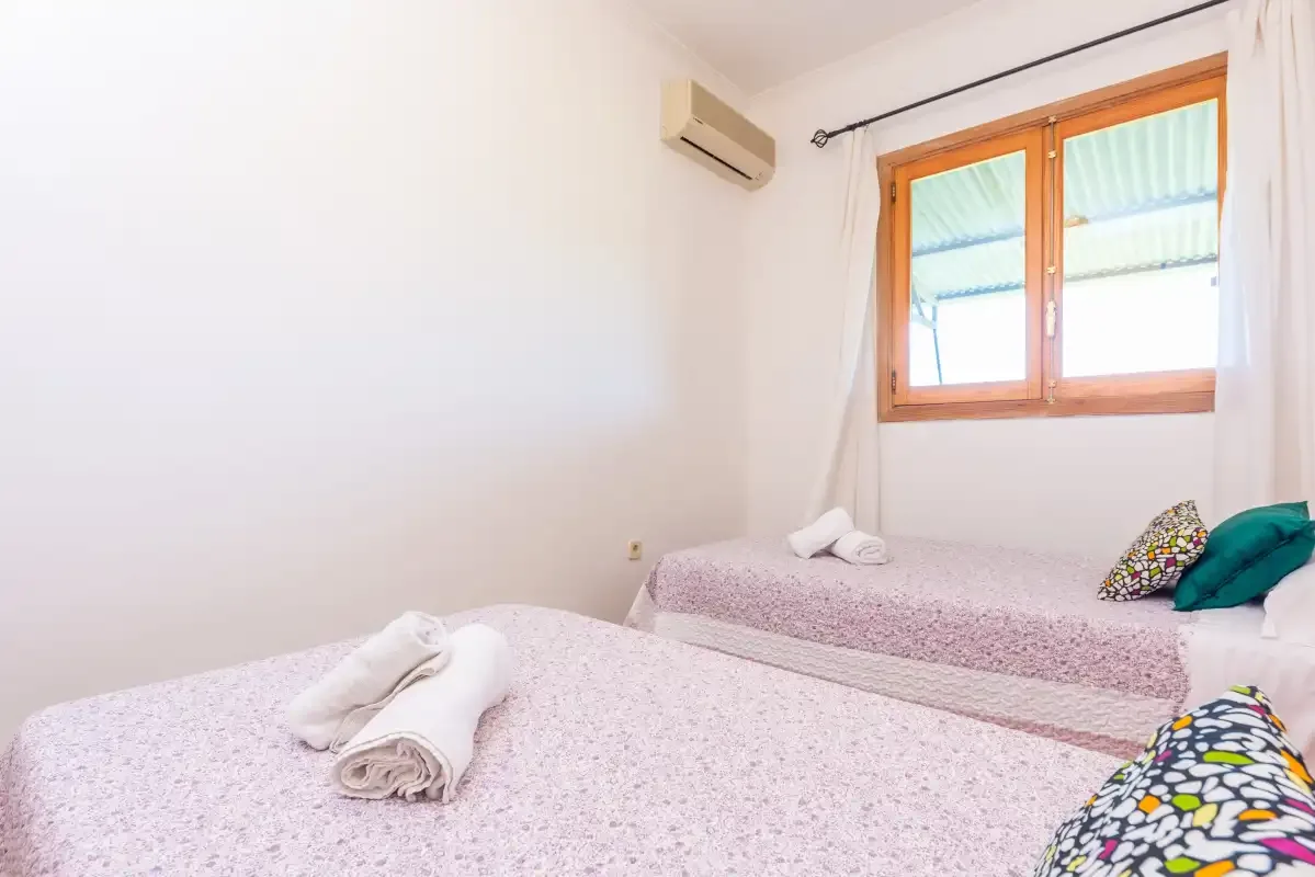 A bedroom with two beds and a window.