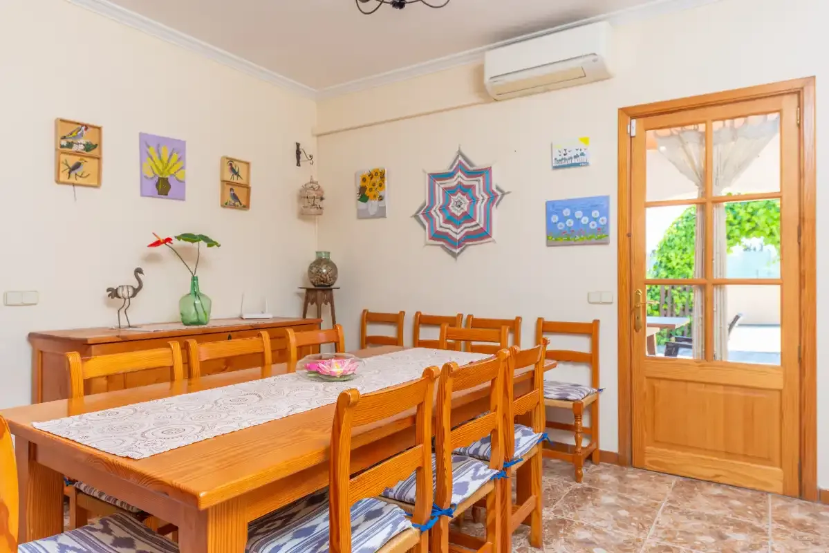 A dining room with a long wooden table and chairs.
