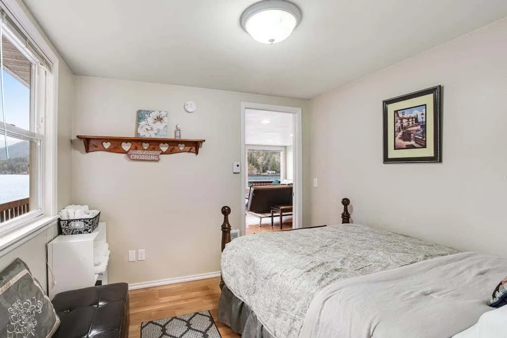 A bedroom with a bed, a window, and a doorway to an adjoining room.