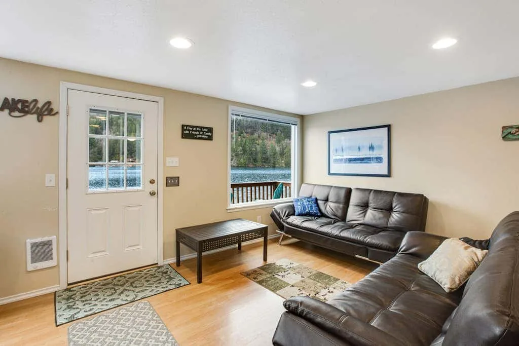 A living room with leather seating, a coffee table, and views of the water.