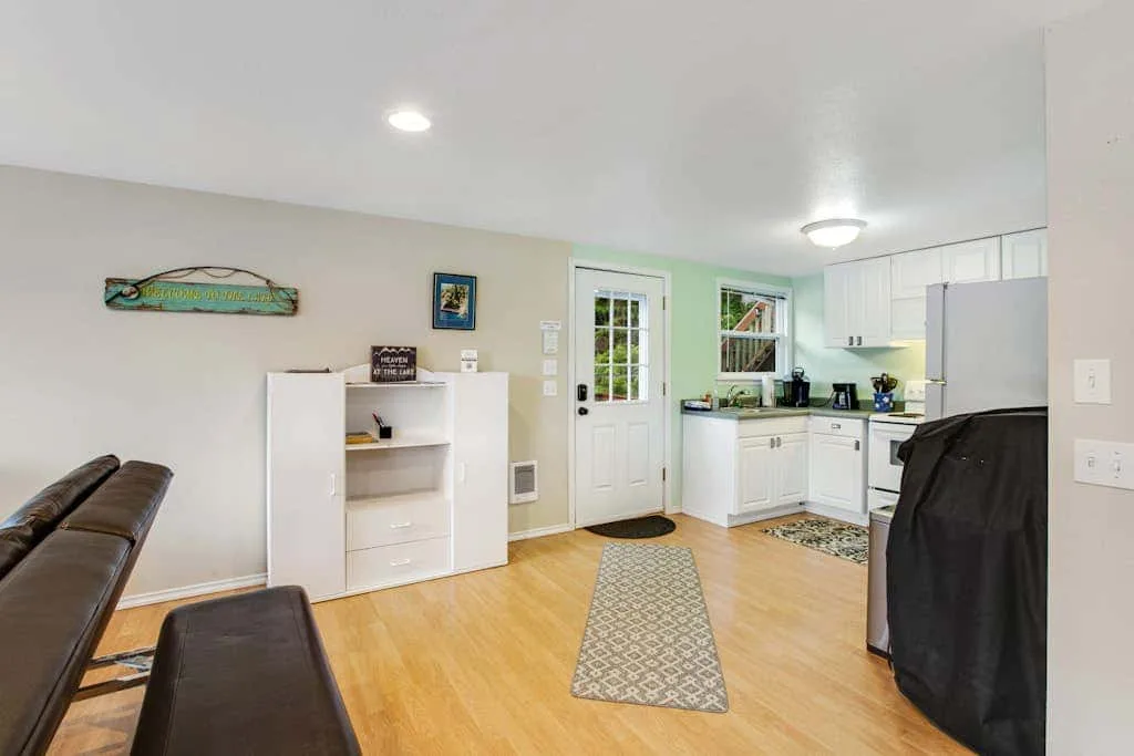 A bright kitchen and dining area with white cabinets and a patterned runner.