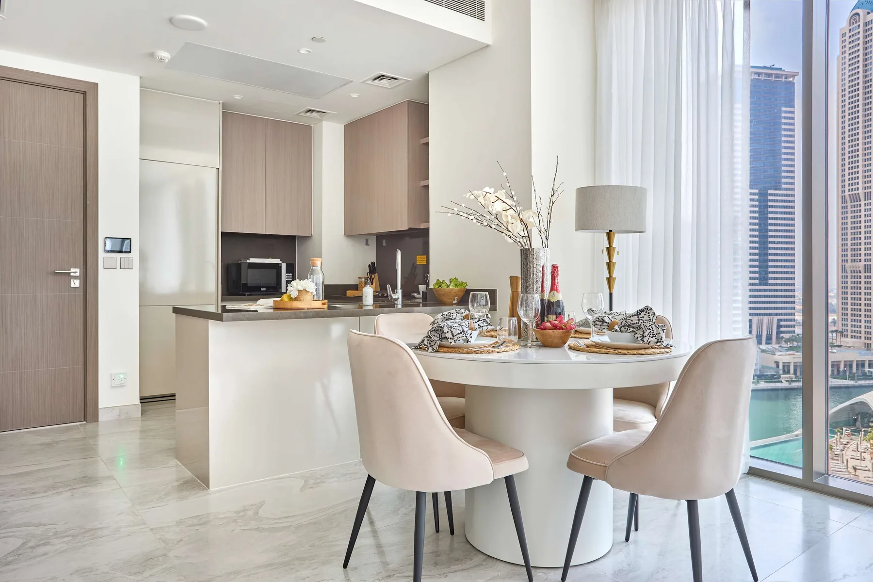 Un comedor luminoso con la mesa puesta junto a grandes ventanales.