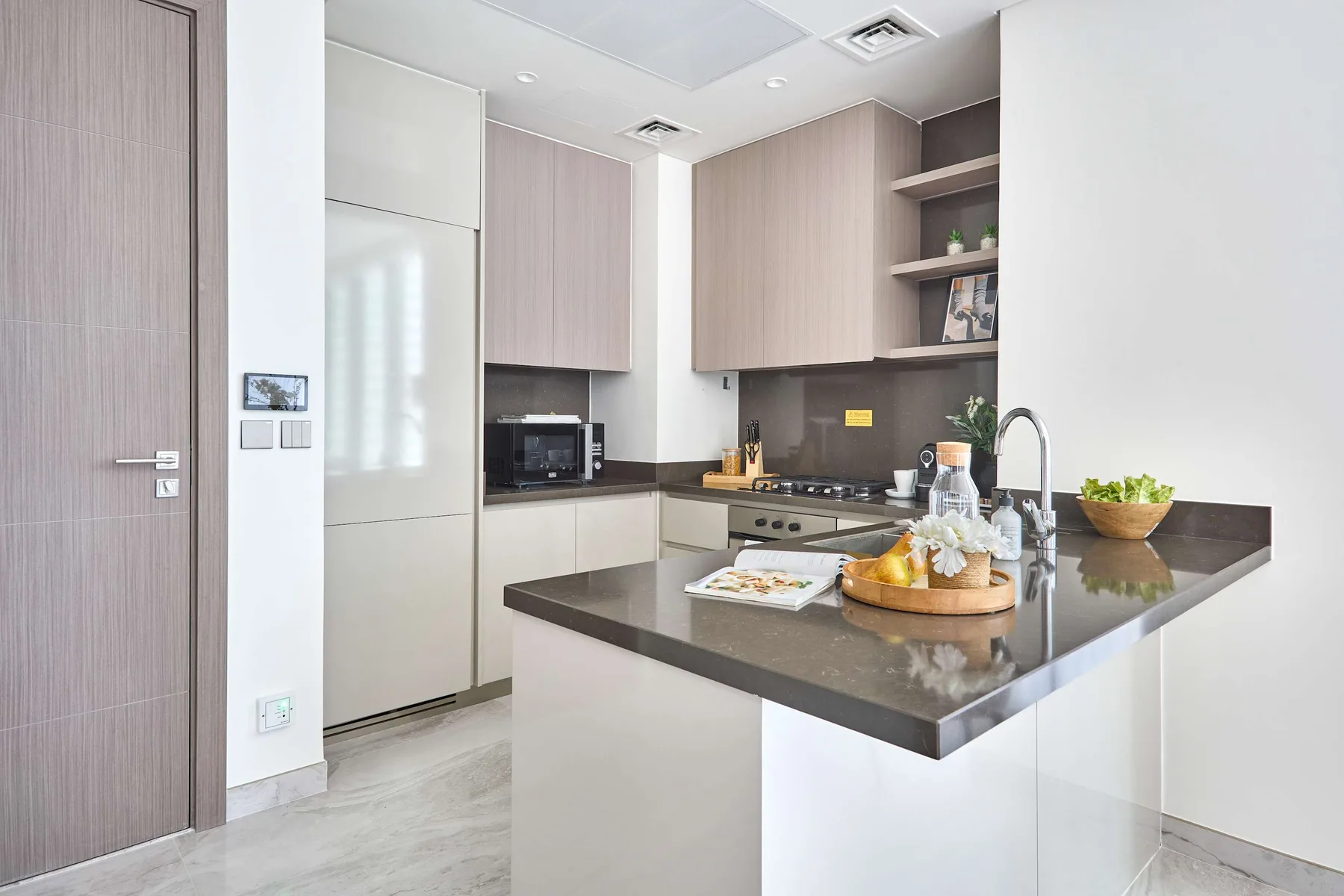 Una cocina moderna con gabinetes claros y una encimera oscura en la isla.