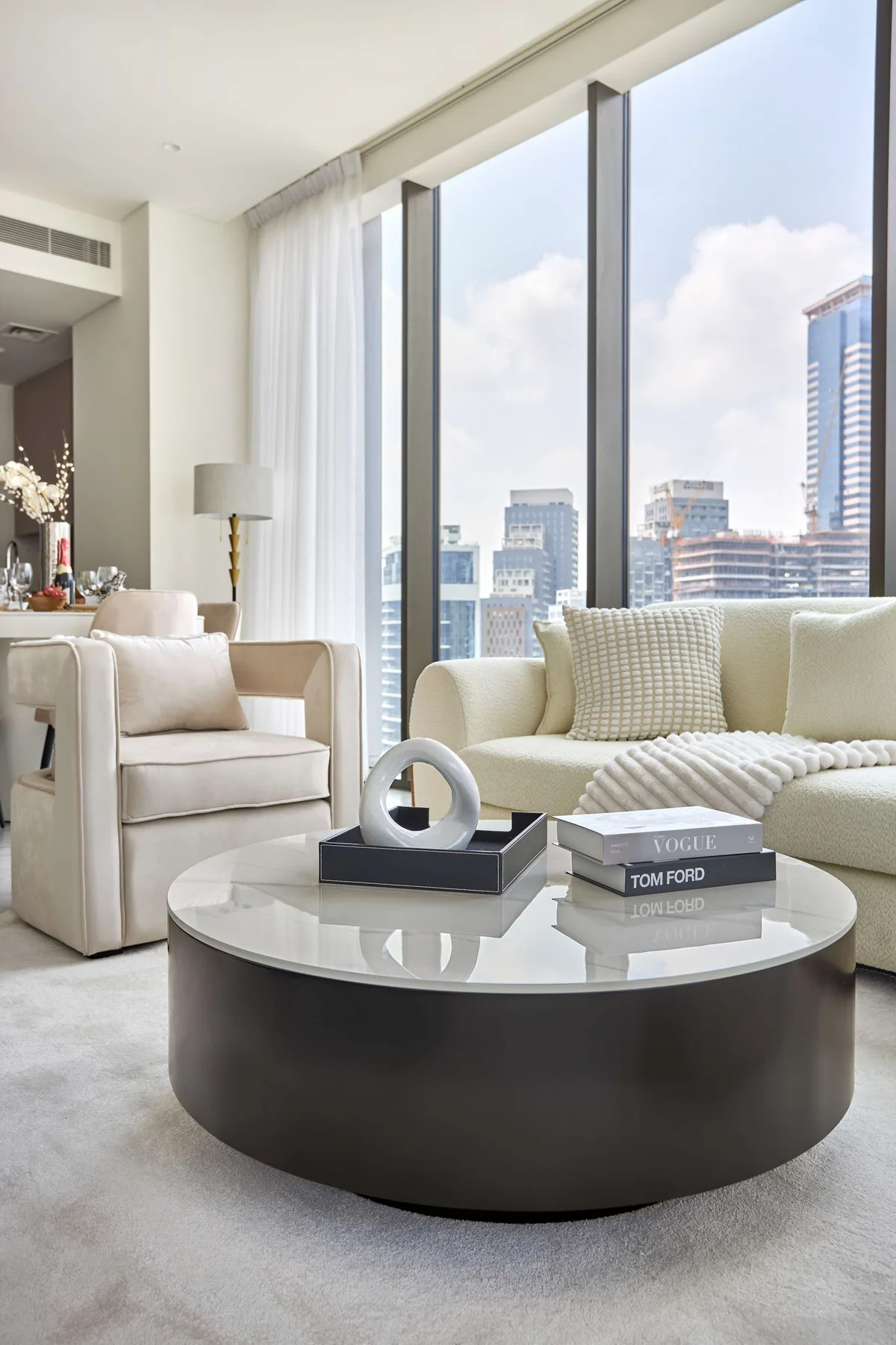 Una sala luminosa con asientos junto a grandes ventanales con vistas a la ciudad.