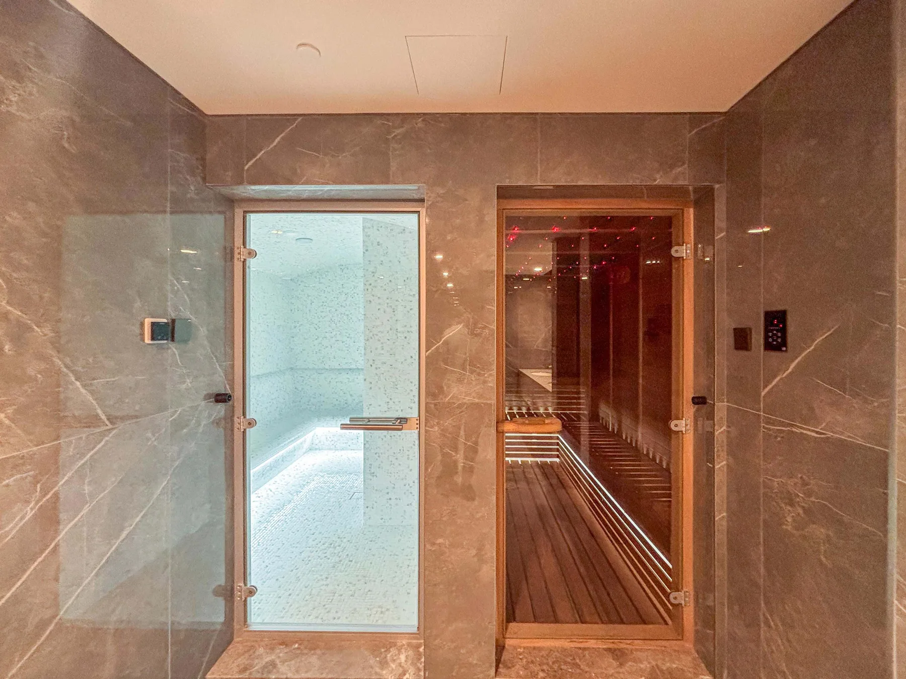 Una sala de spa con un baño de vapor y una sauna de madera.