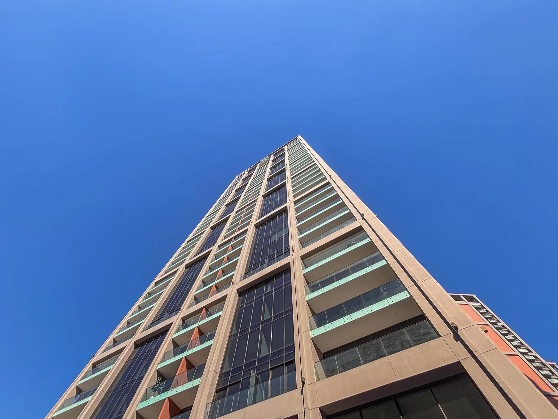 Un edificio moderno y alto se alza contra un cielo azul despejado.