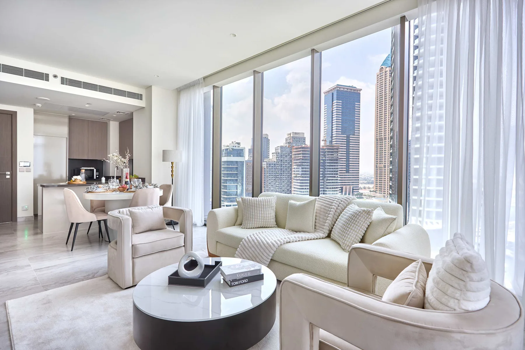 Una sala luminosa con asientos junto a grandes ventanas con vistas a edificios de la ciudad.
