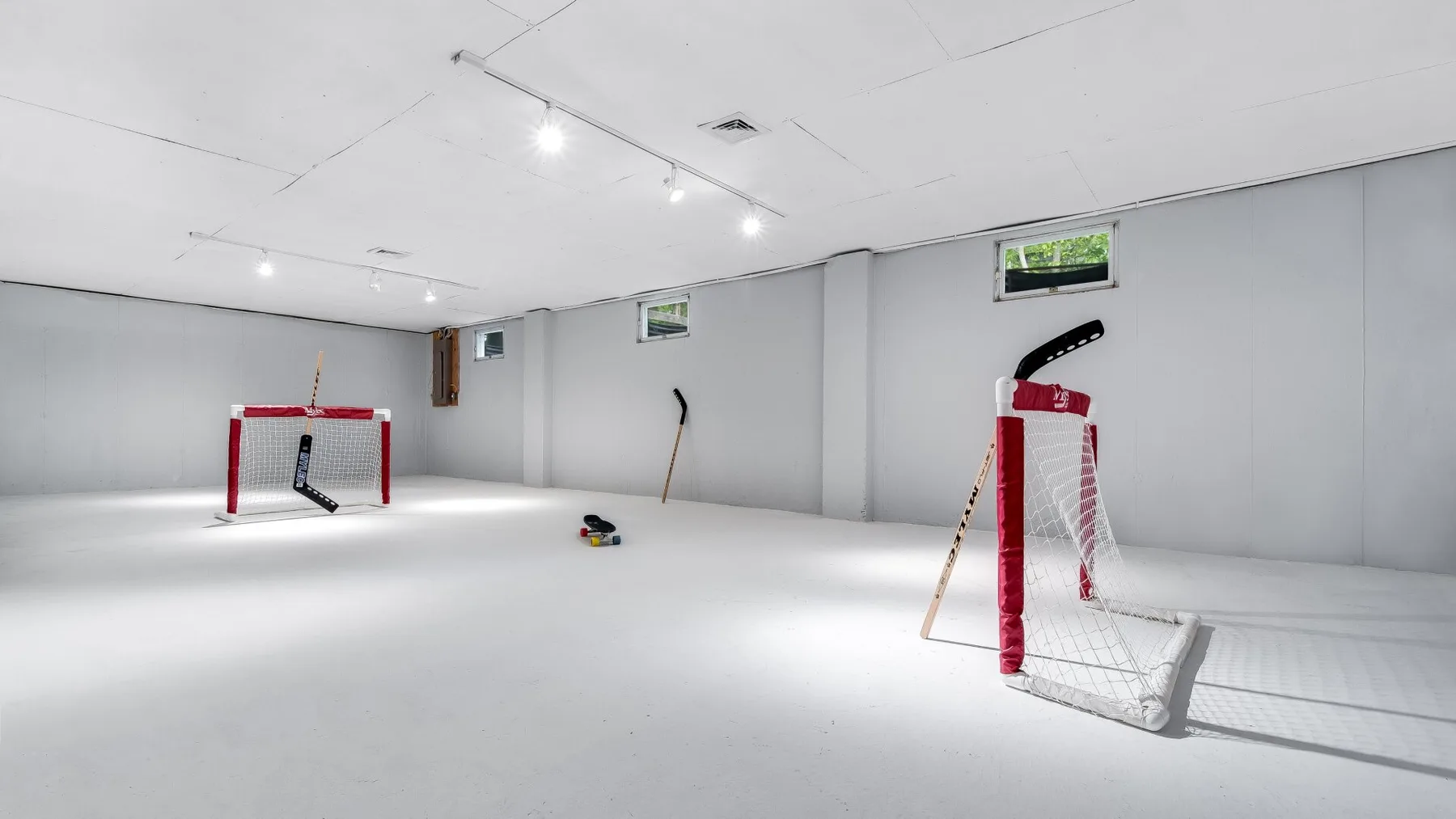 Una pista de hockey cubierta con porterías y palos en el suelo.