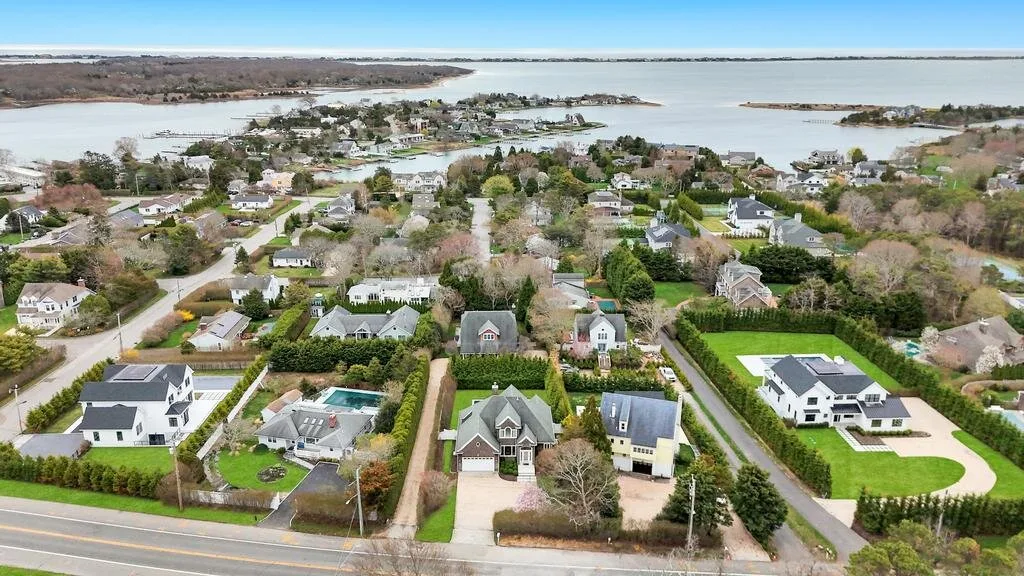 An aerial view of a residential neighborhood beside a broad body of water.