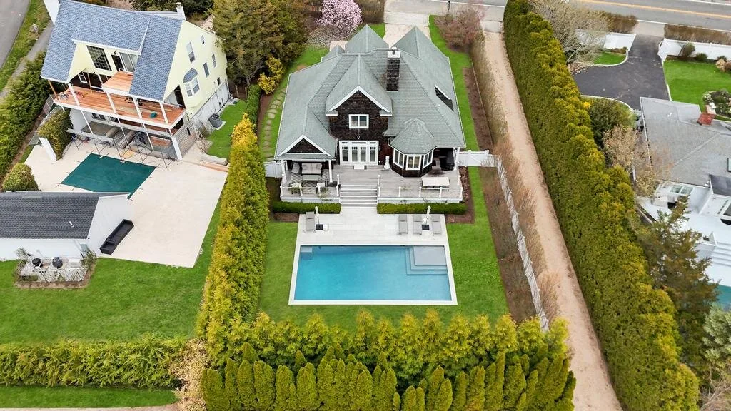 An aerial view shows a large house, a swimming pool, and surrounding hedges.