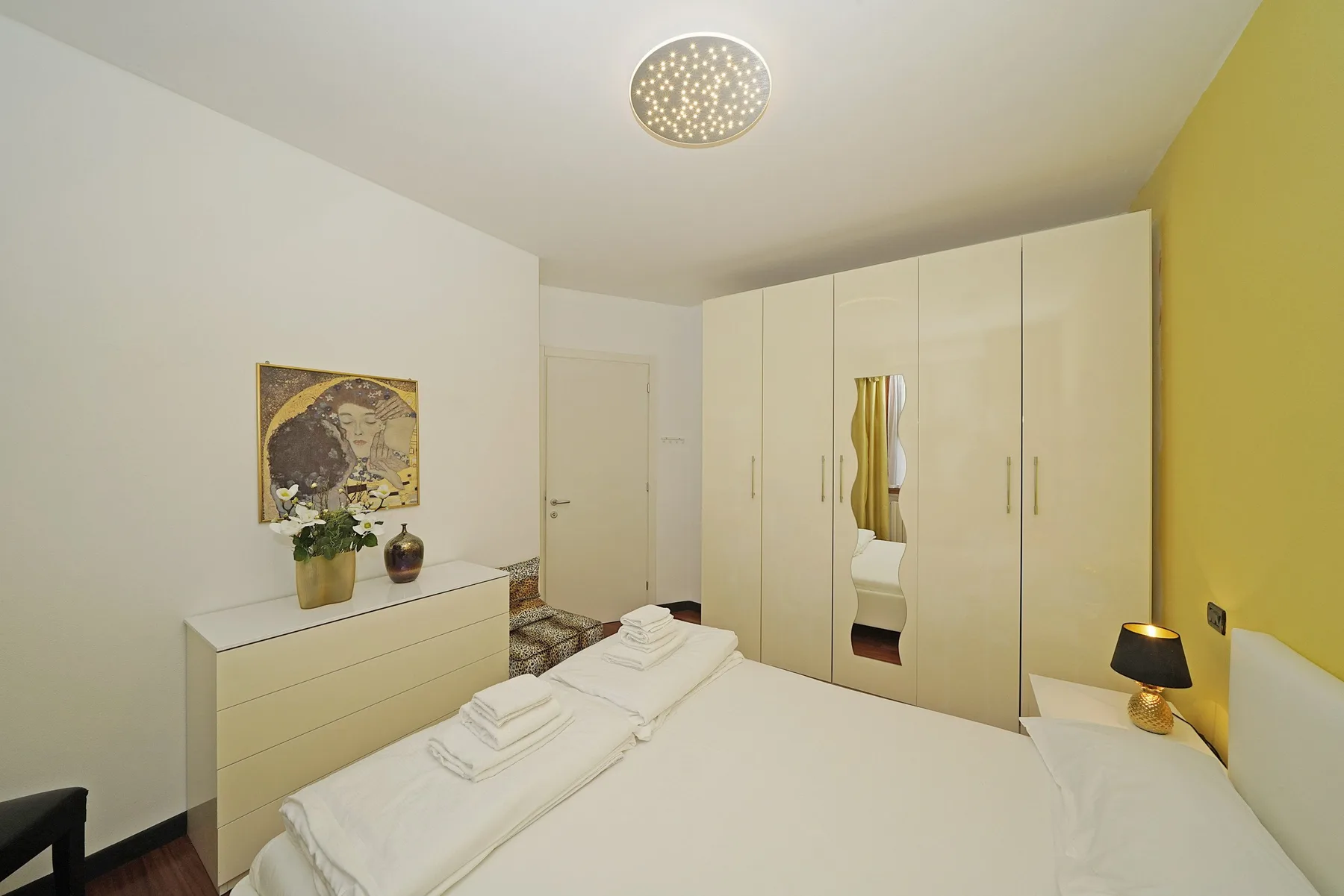 Un dormitorio con una cama bien hecha y un armario grande.