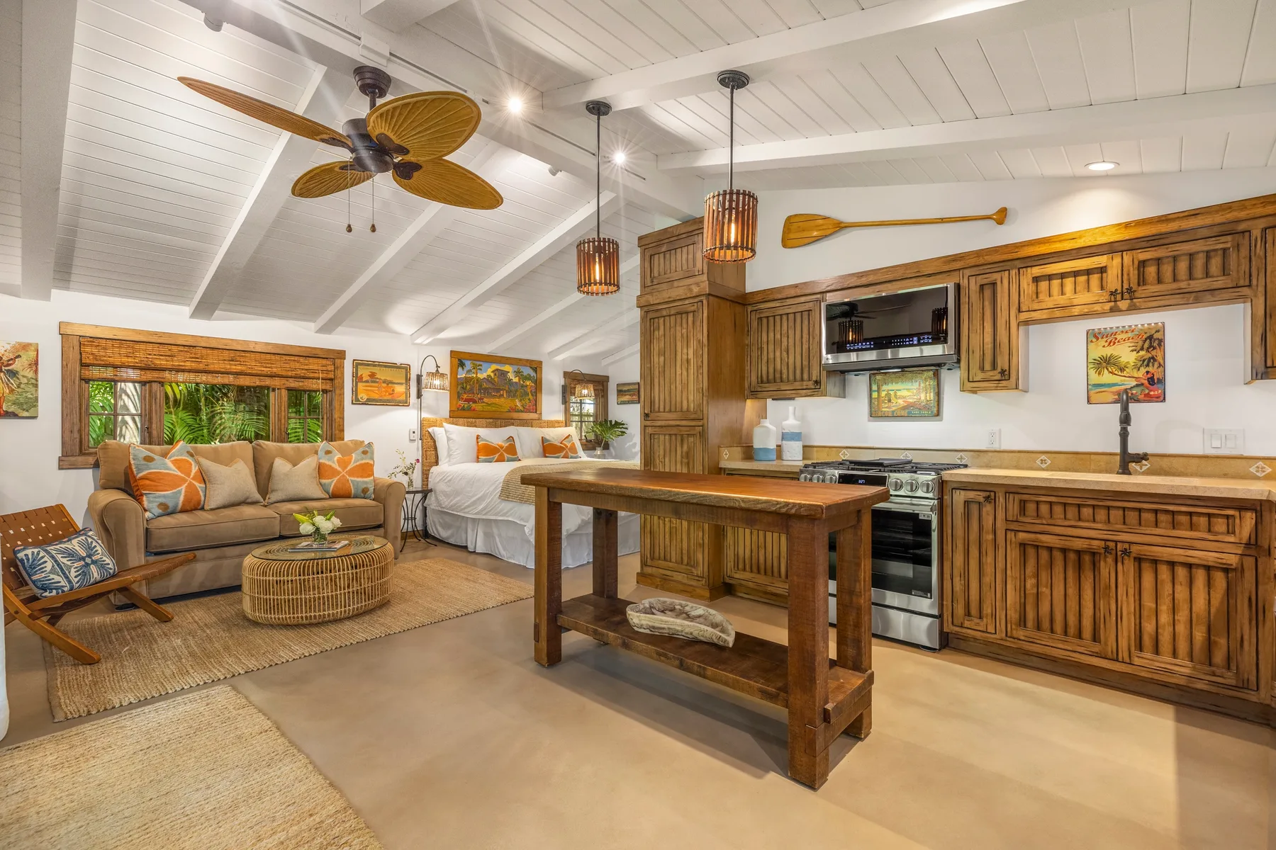Open-plan living area with a kitchen island, seating, and a bed.