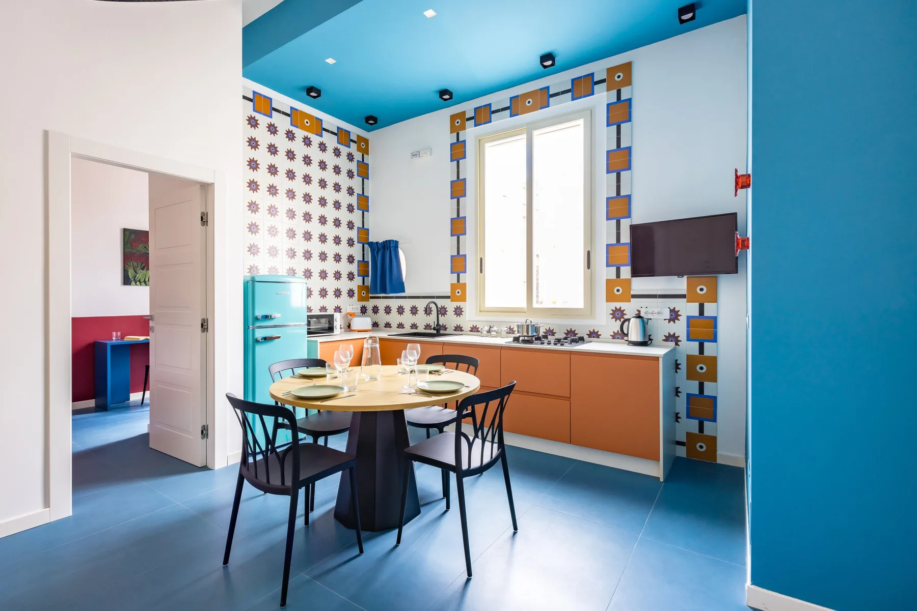 A colorful kitchen and dining area with a table beside the counter.