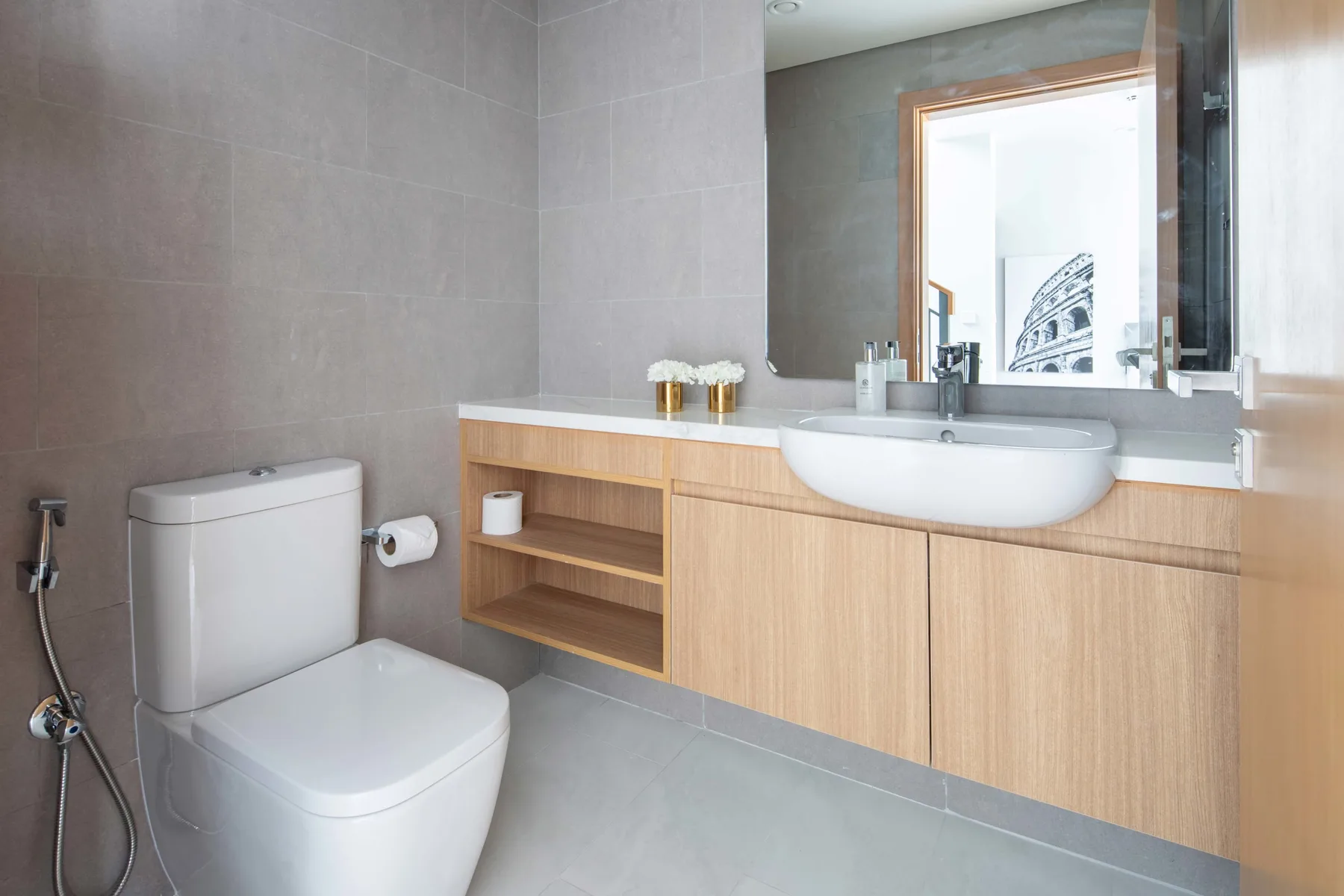 Un baño con azulejos, inodoro y un mueble de madera con lavabo.
