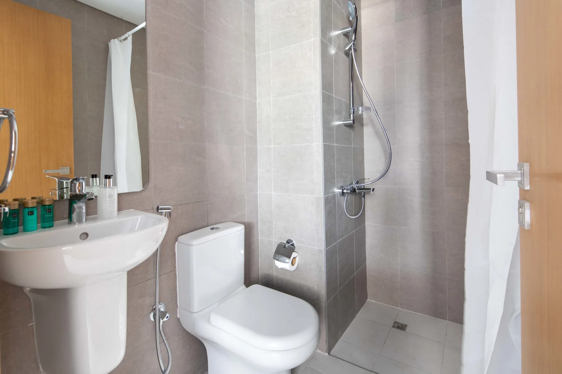 Un baño con azulejos, lavabo, inodoro y ducha.
