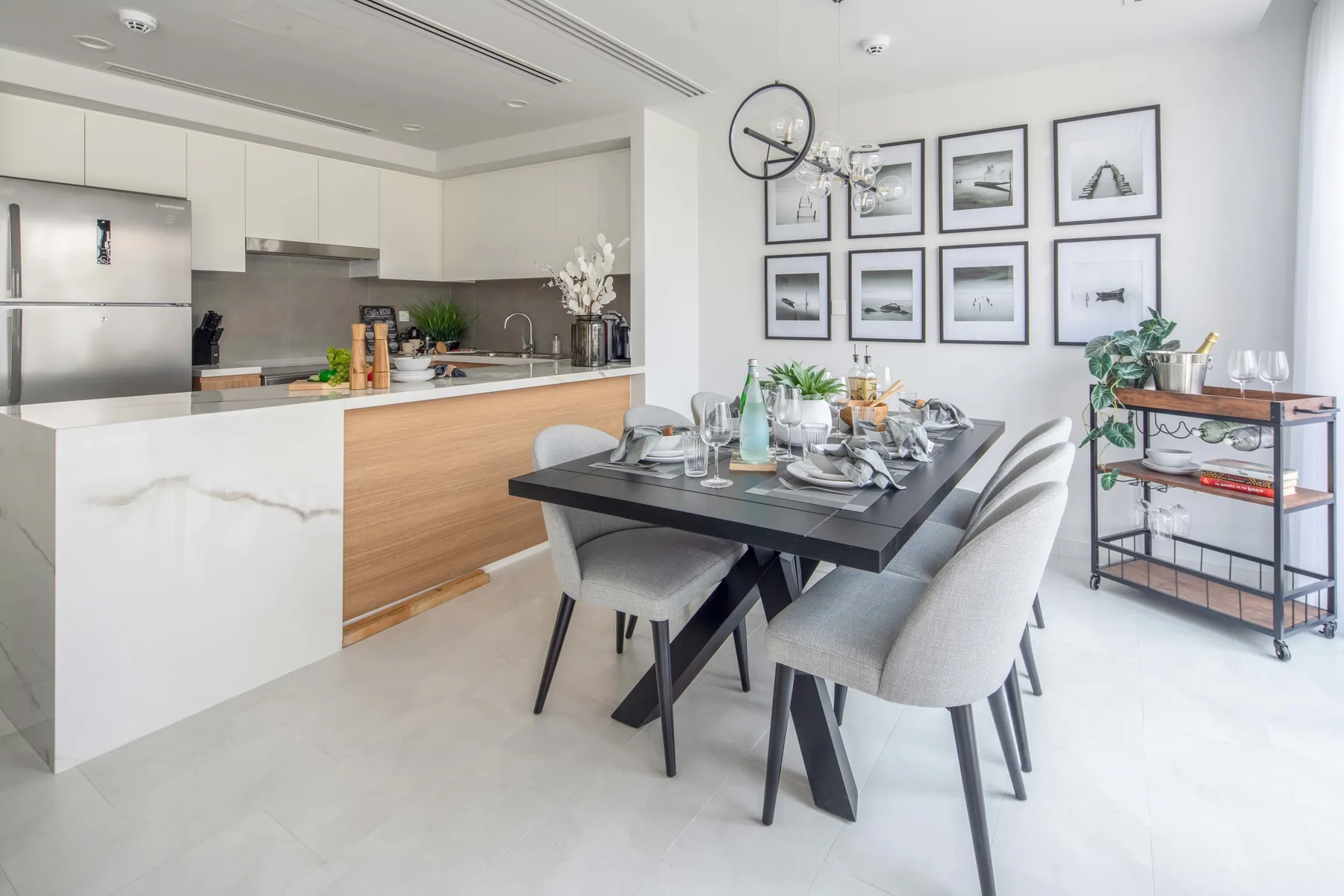 Un comedor con la mesa puesta junto a una cocina abierta.