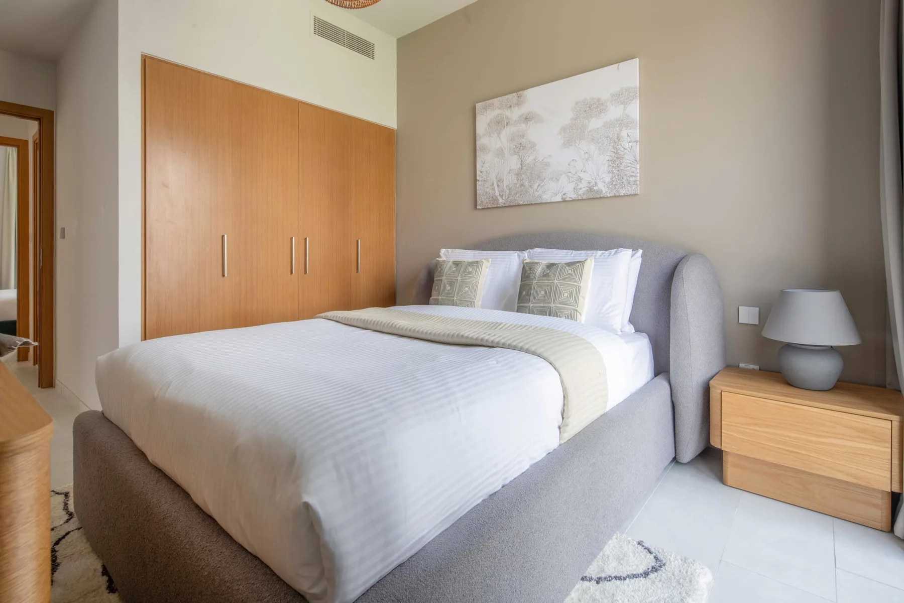 Un dormitorio con una cama tendida y puertas de armario de madera.