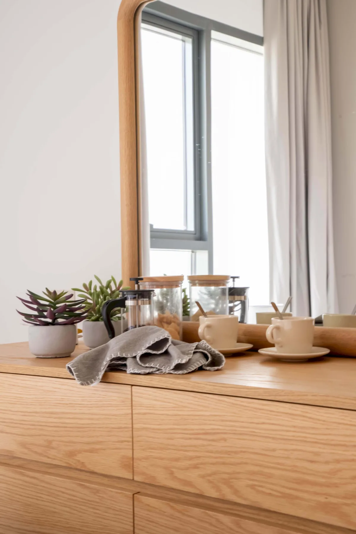Una habitación luminosa con una encimera de madera, un juego de té y una ventana.