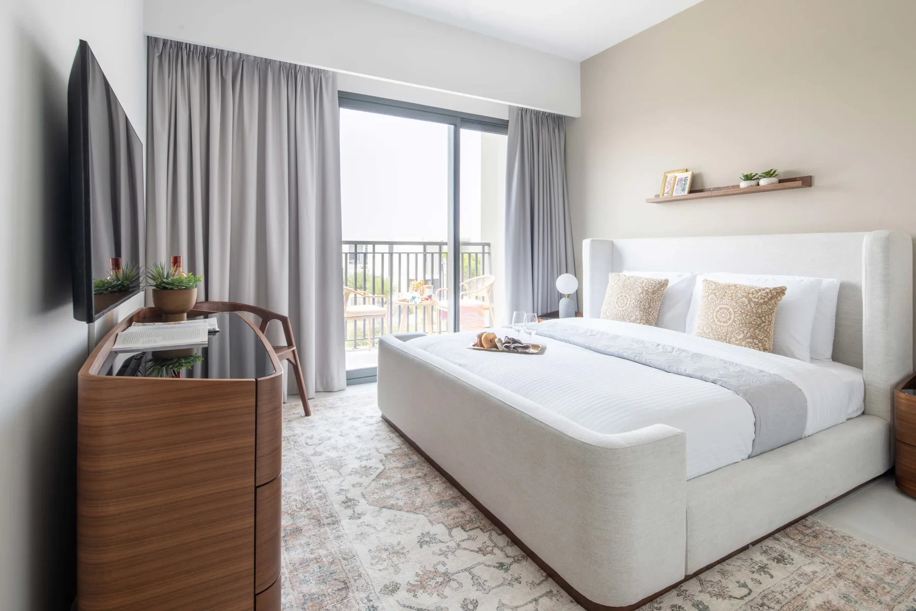 Un dormitorio luminoso con una cama grande y una puerta corrediza de vidrio.