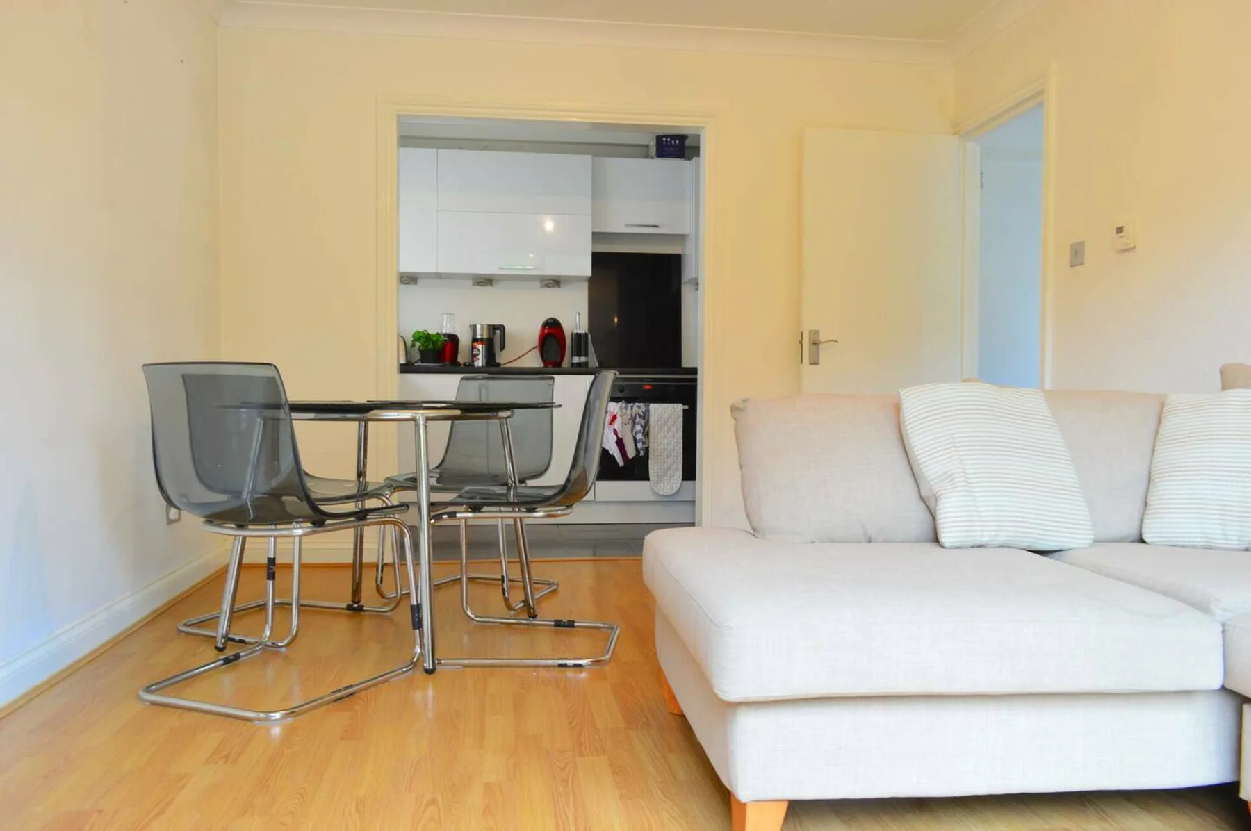 Living area with seating and a dining table beside an open kitchen.
